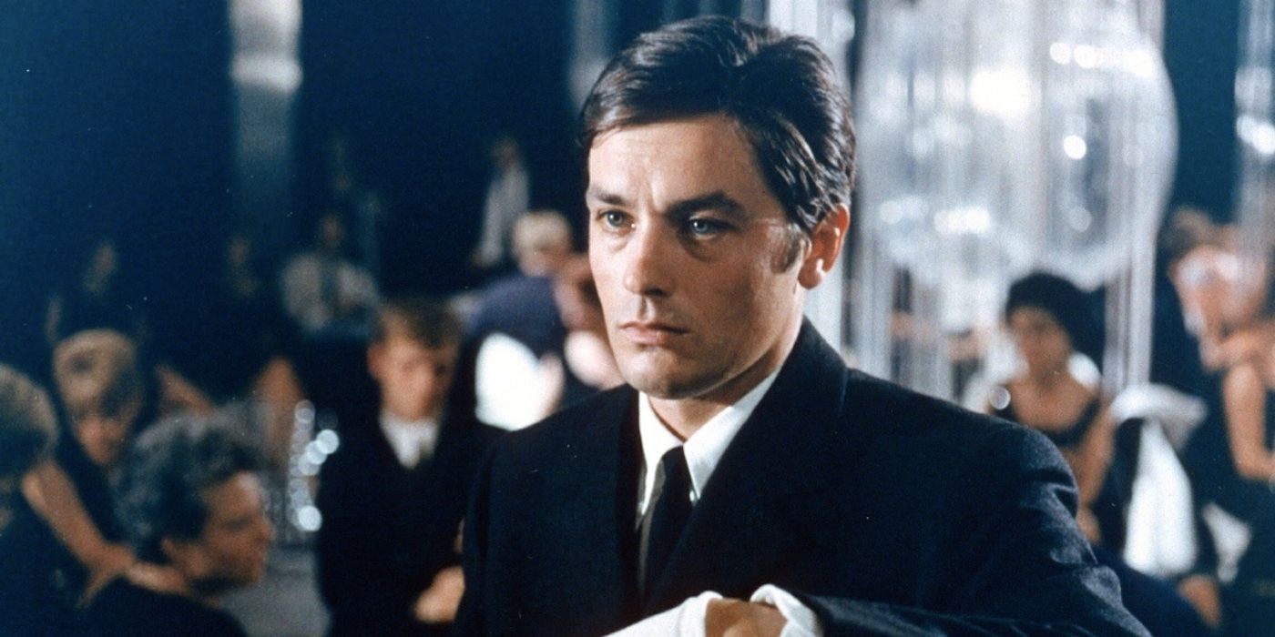 Alain Delon looking to the left of the camera in a crowded room in Le Samouraï