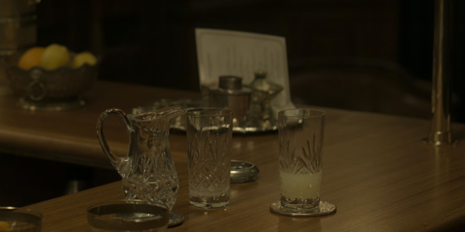 A half drank glass of alcohol sits on the bar in The Crown season 6.