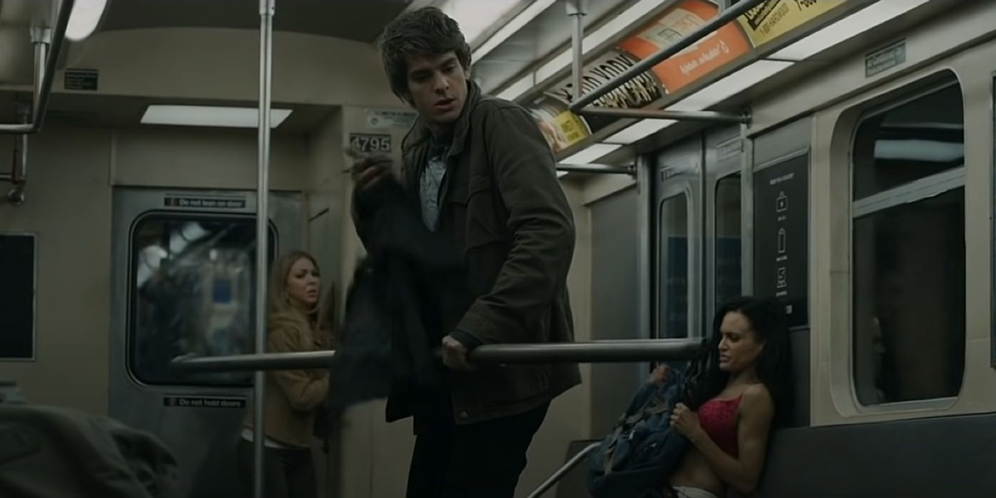 Andrew Garfield as Peter Parker holding a subway pole in The Amazing Spider-Man