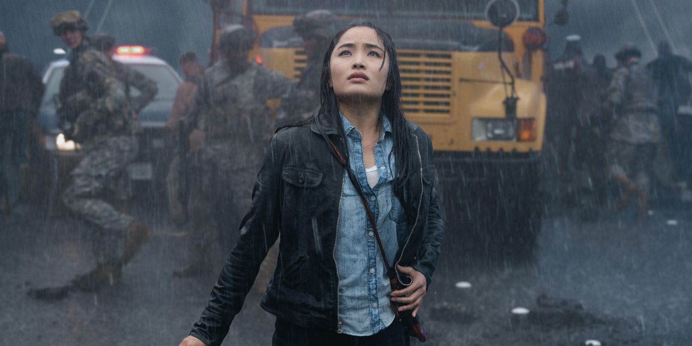Anna Sawai as Cate looking up at Godzilla in the rain in a flashback in Monarch: Legacy of Monsters
