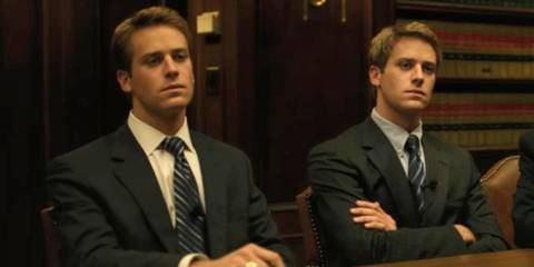 Armie Hammer as the Winklevoss Twins sitting at a table in The Social Network