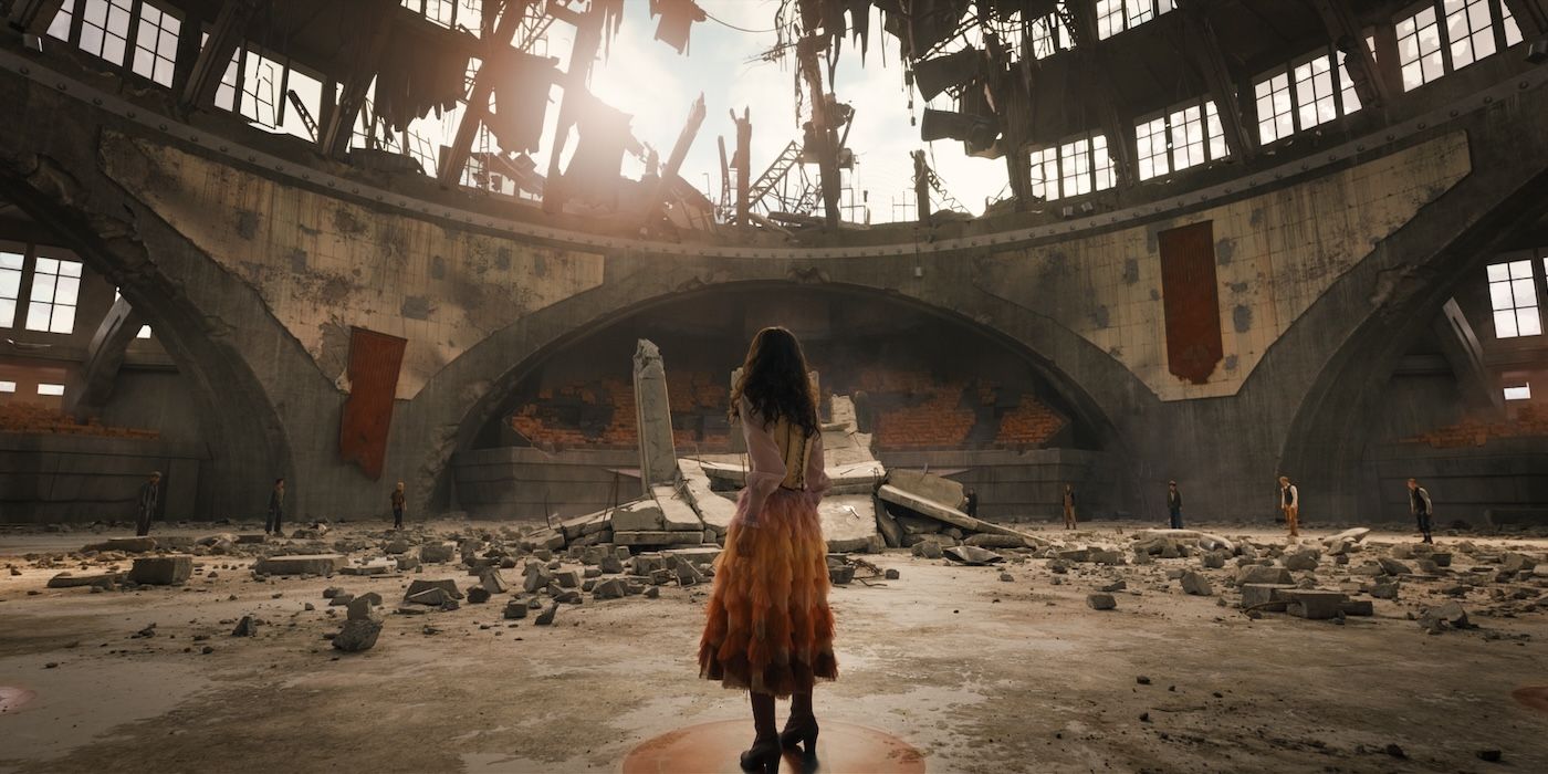 Rachel Zegler as Lucy Gray standing in the destroyed arena in The Hunger Games: The Ballad of Songbirds and Snakes