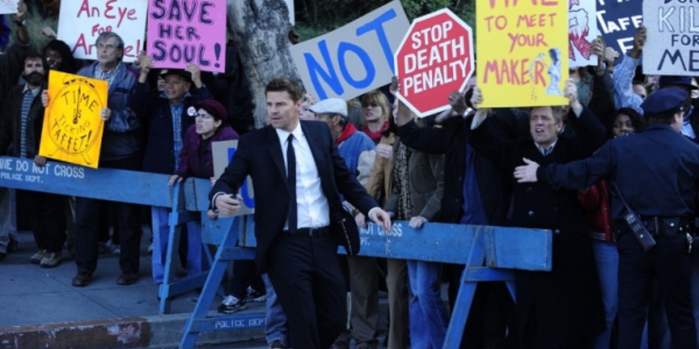 David Boreanaz as Seeley Booth in front of a crowd of protesters in Bones