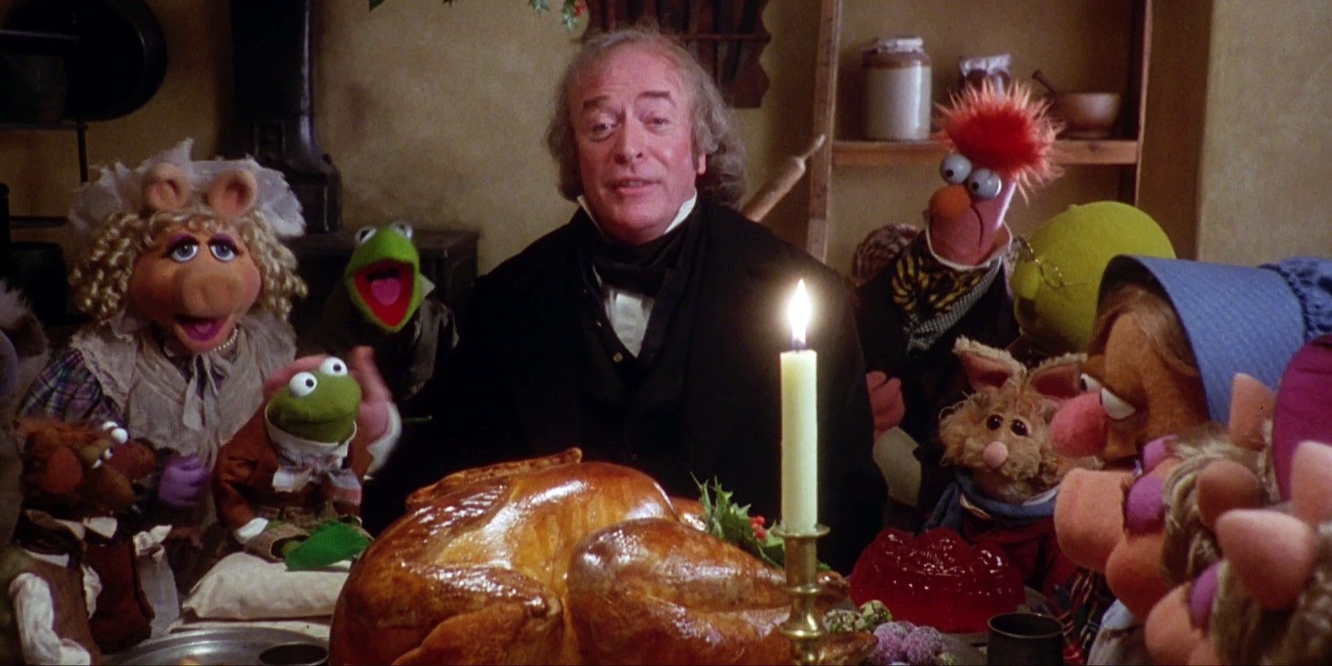 Ebeneezer Scrooge (Michael Caine) and the Muppets gathered around a Christmas turkey dinner in A Muppet Christmas Carol