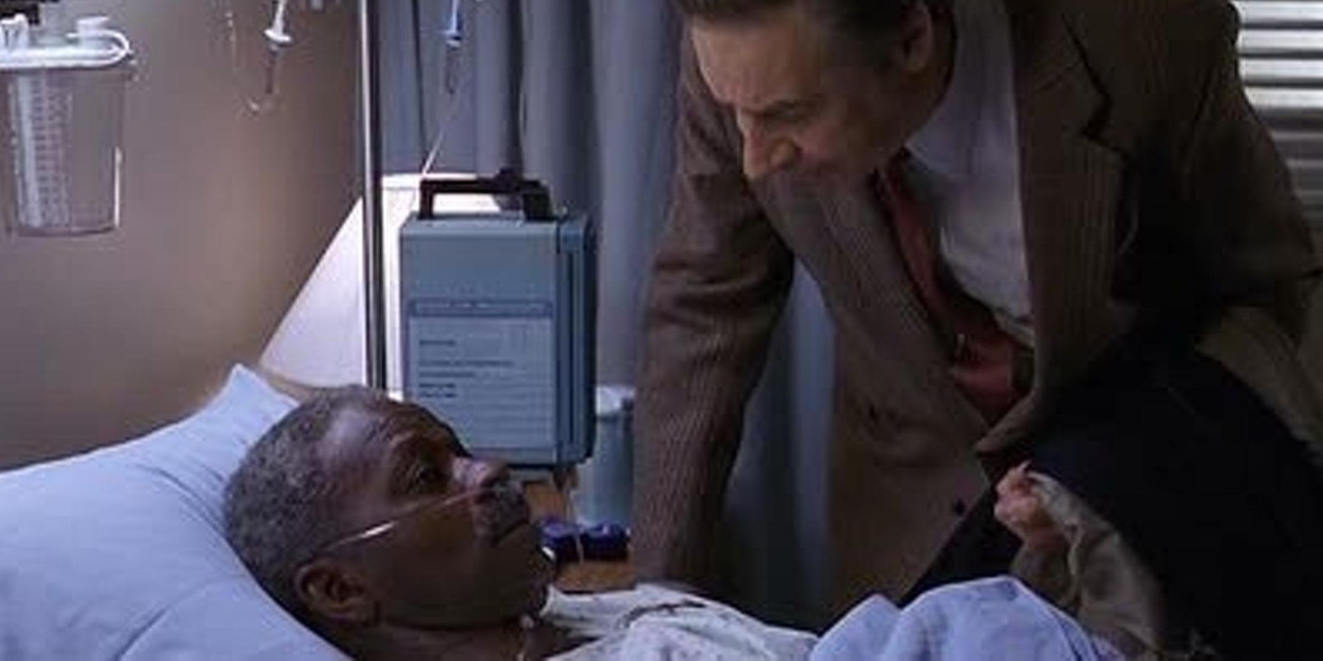 Jack McCoy leaning over another man in a hospital bed in Law & Order episode Charm City