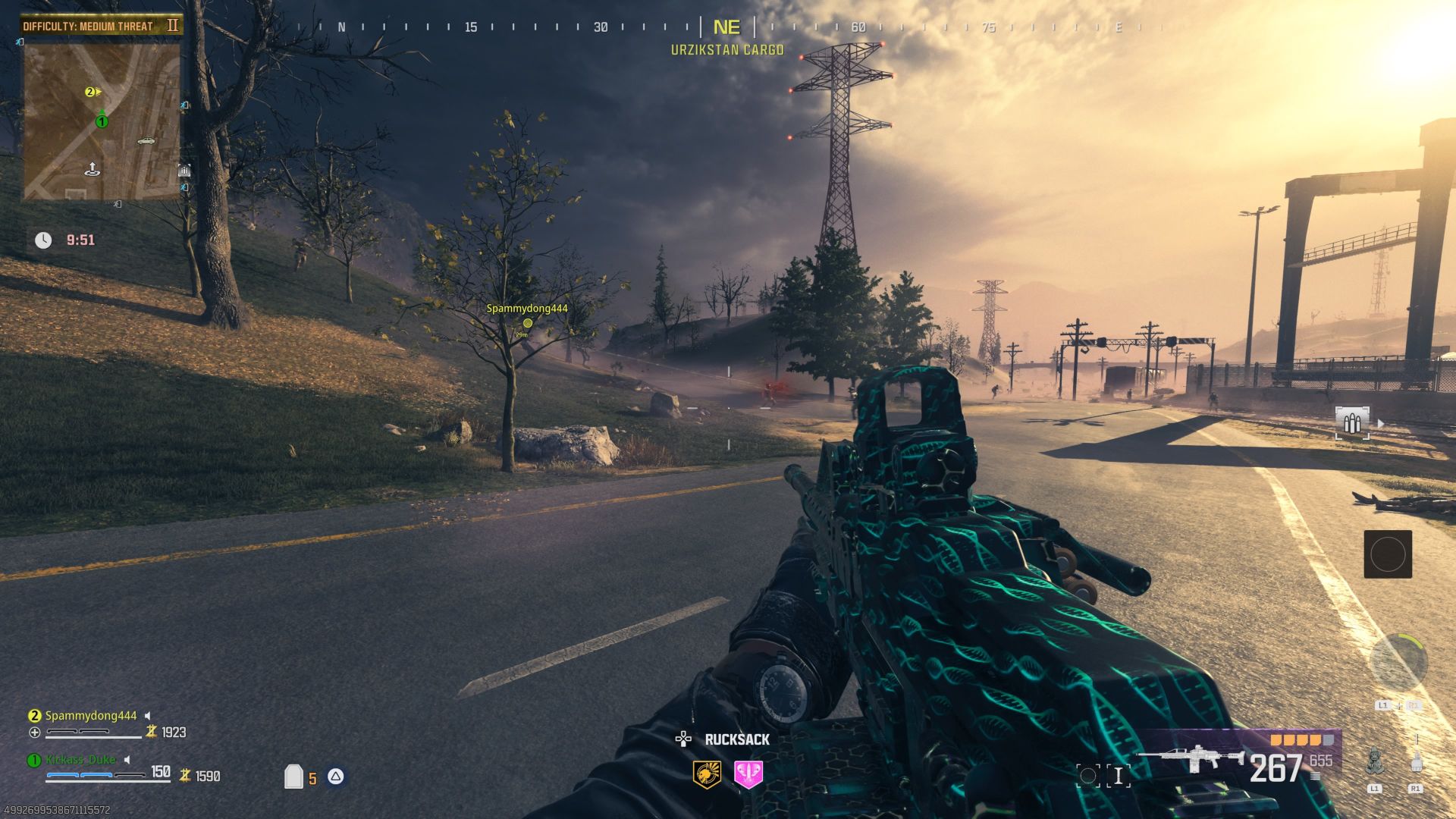 Screenshot from MW3 Zombie mode shows a large field populated by a scarce amount of trees and communication towers with around a half dozen zombies shambling around while the player holds a large machine gun.