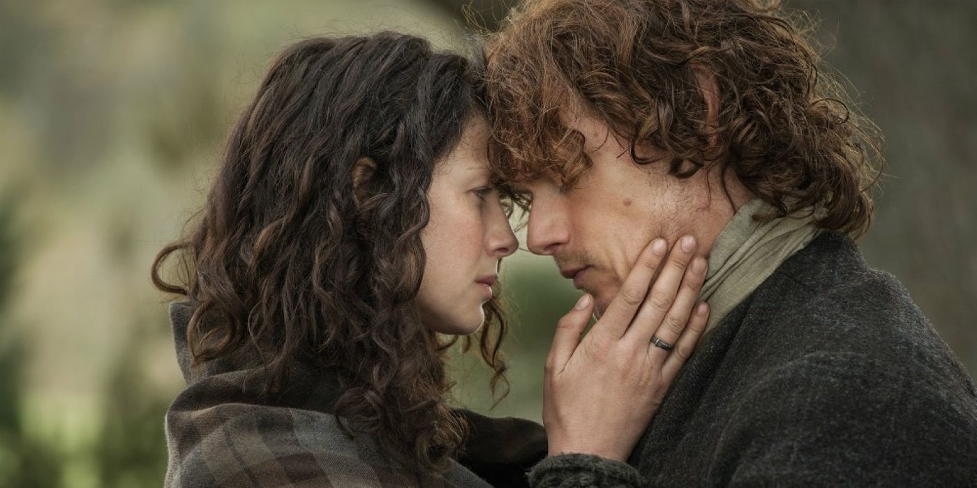 Claire and Jamie holding each other close in a loving embrace in Outlander