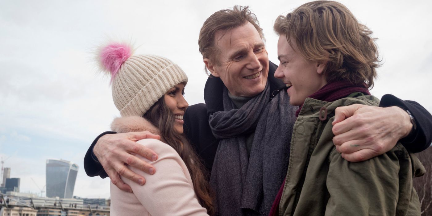 Daniel (Liam Neeson), Sam (Thomas Brodie-Sangster), and Joanna (Olivia Olson) hugging in Red Nose Day Actually