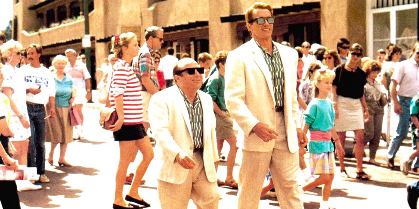 Danny DeVito and Arnold Schwarzenegger shuffle down the street wearing matching outfitsin Twins