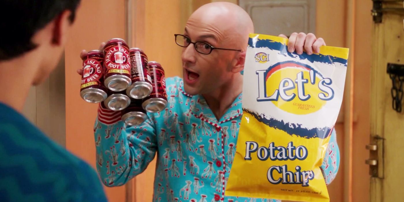 Dean Pelton (Jim Rash) wears pajamas and holds root beer and chips in Community.