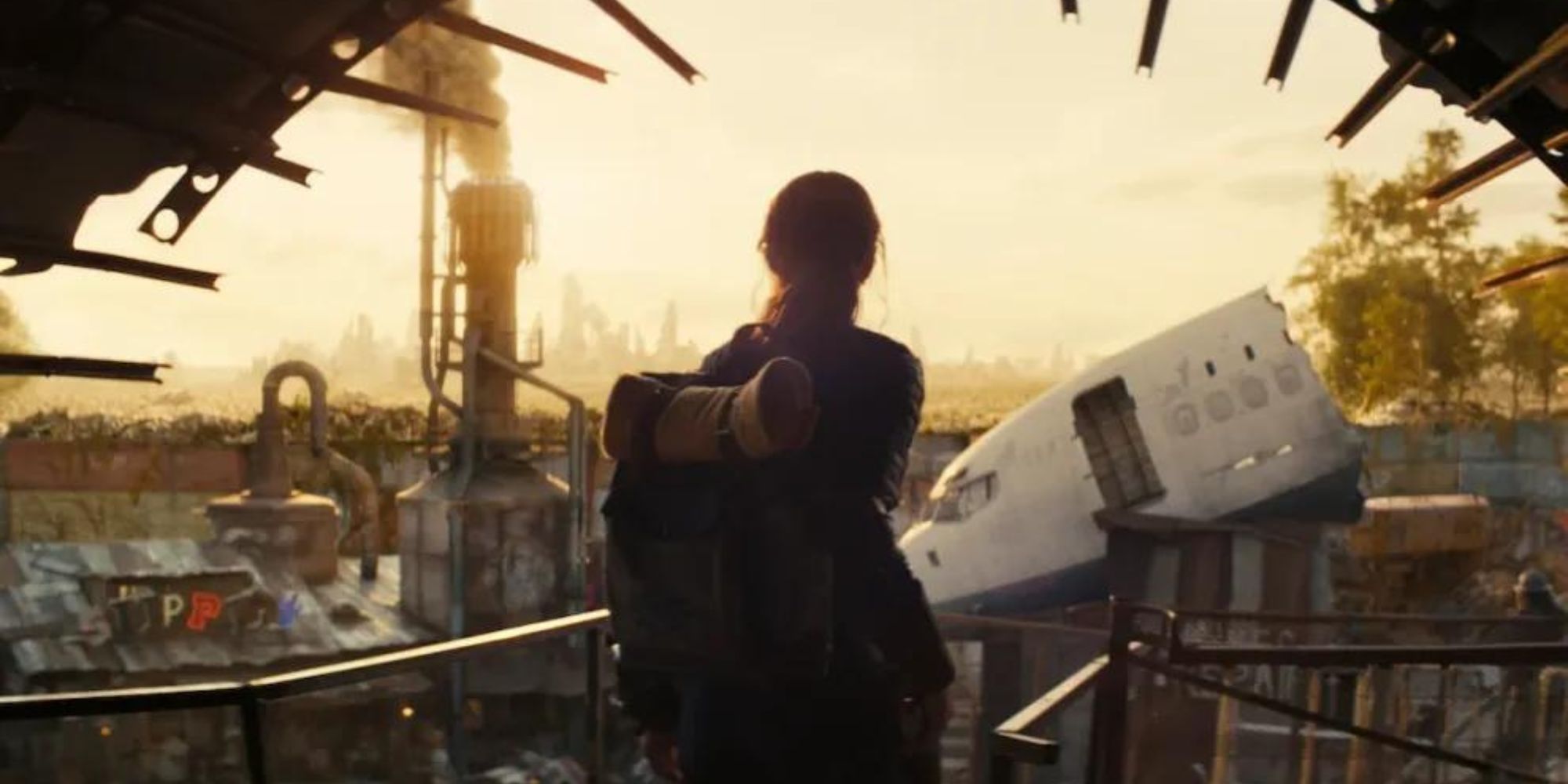 Ella Purnell as Lucy stands on a balcony and looks off into the distance of a dilapidated city in the Fallout TV show