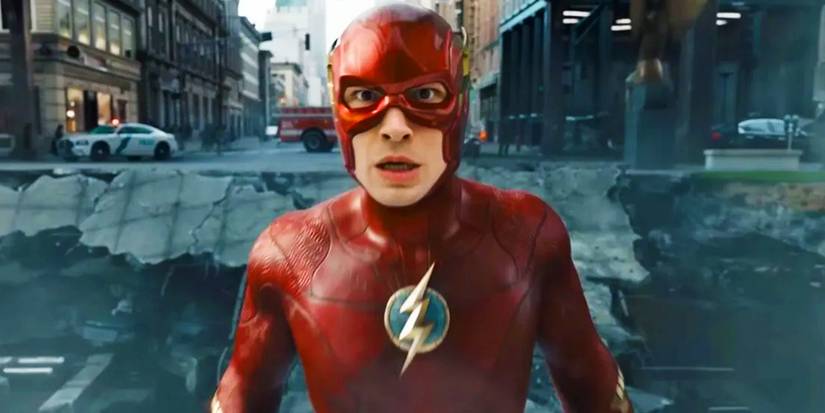 Ezra Miller's Flash looking shocked and standing in a damaged road in The Flash