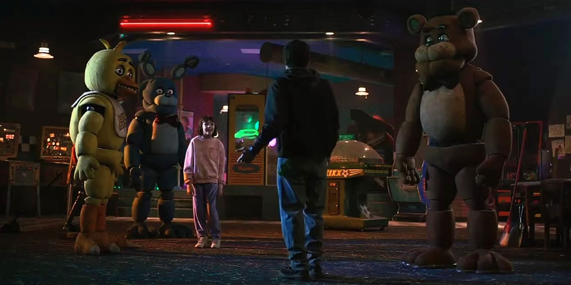 Mike and Abby stand in front of Fazbear's with the animatronics in the FNAF movie