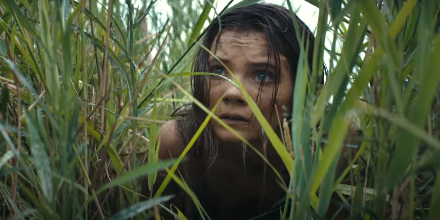 Freya Allan as Mae hiding in tall grass in Kingdom of the Planet of the Apes