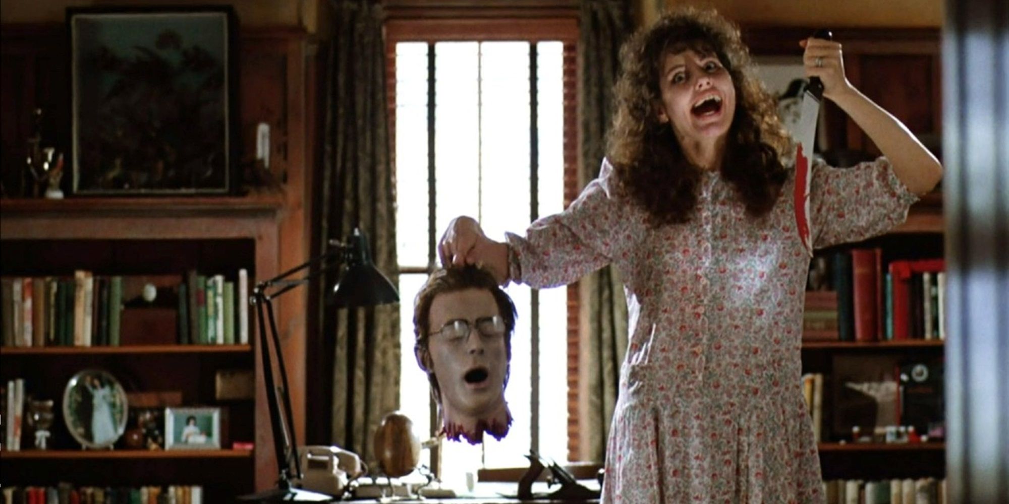 Geena Davis holding a knife and a severed head in Beetlejuice