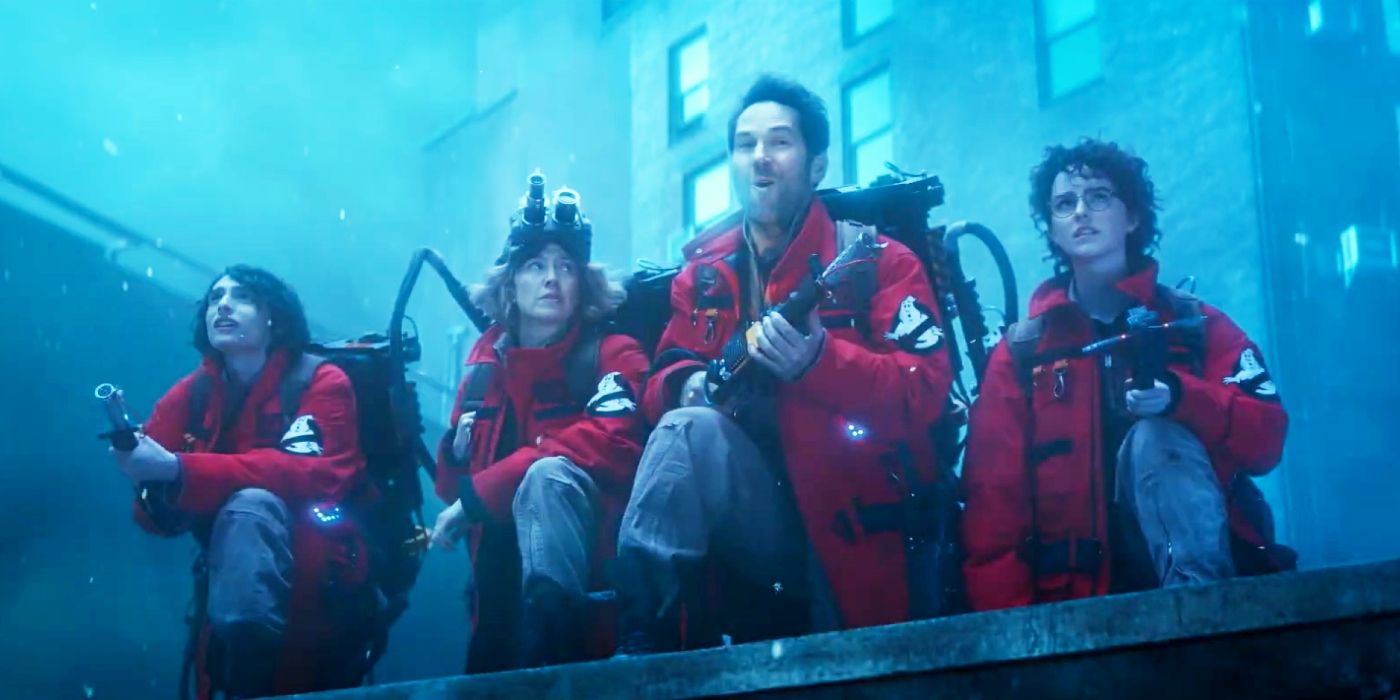 Finn Wolfhard, Carrie Coon, Paul Rudd, and McKenna Grace wearing red, cold-weather Ghostbusters uniforms in Ghostbusters: Frozen Empire.