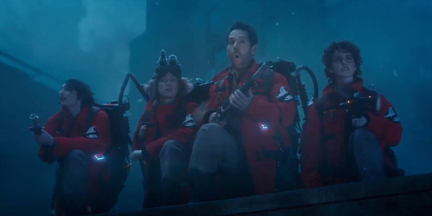 Paul Rudd as Gary Grooberson, Finn Wolfhard as Trevor, Carrie Coon as Callie, and McKenna Grace as Phoebe Spengler stand on a rooftop with proton packs in Ghostbusters: Frozen Empire.