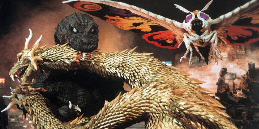 Godzilla biting Ghidorah while Mothra flies in Godzilla, Mothra and King Ghidorah Giant Monsters All-Out Attack