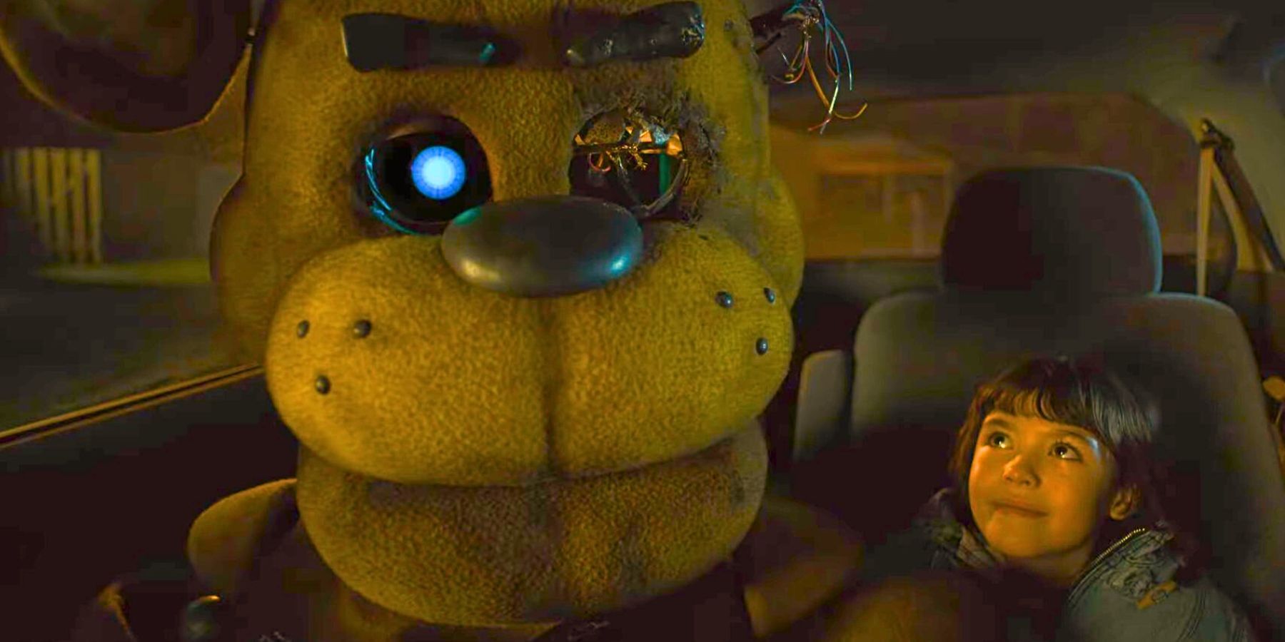 Golden Freddy sitting in a car with Abby (Piper Rubio) in the FNAF movie