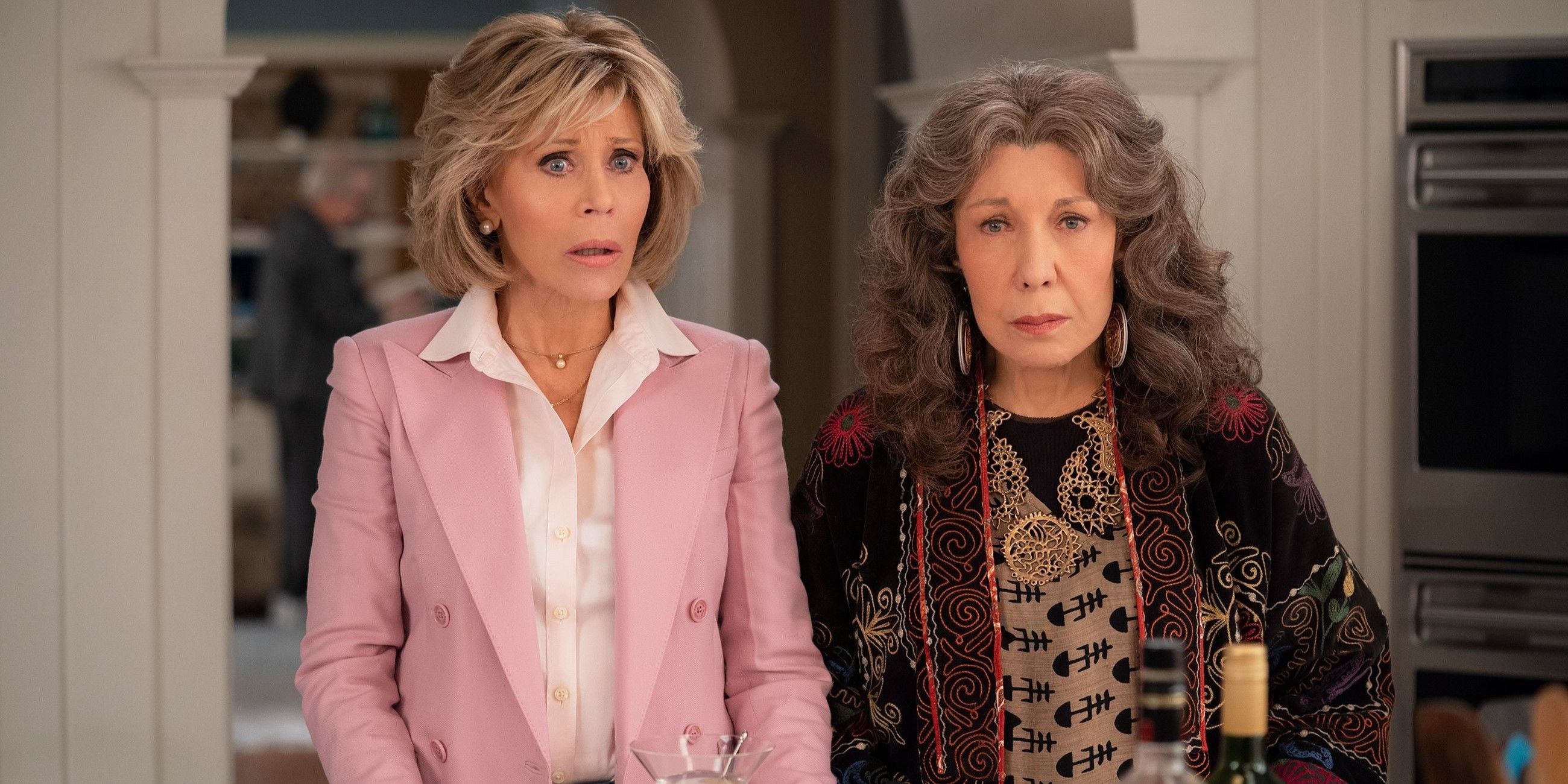 Grace (Jane Fonda) and Frankie (Lily Tomlin) standing in their kitchen looking concerned in Grace and Frankie