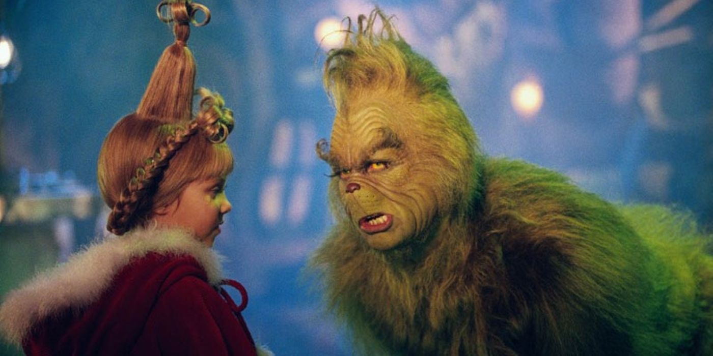 Jim Carrey as the Grinch leaning in close to Taylor Momsen as Cindy Lou Who in How The Grinch Stole Christmas
