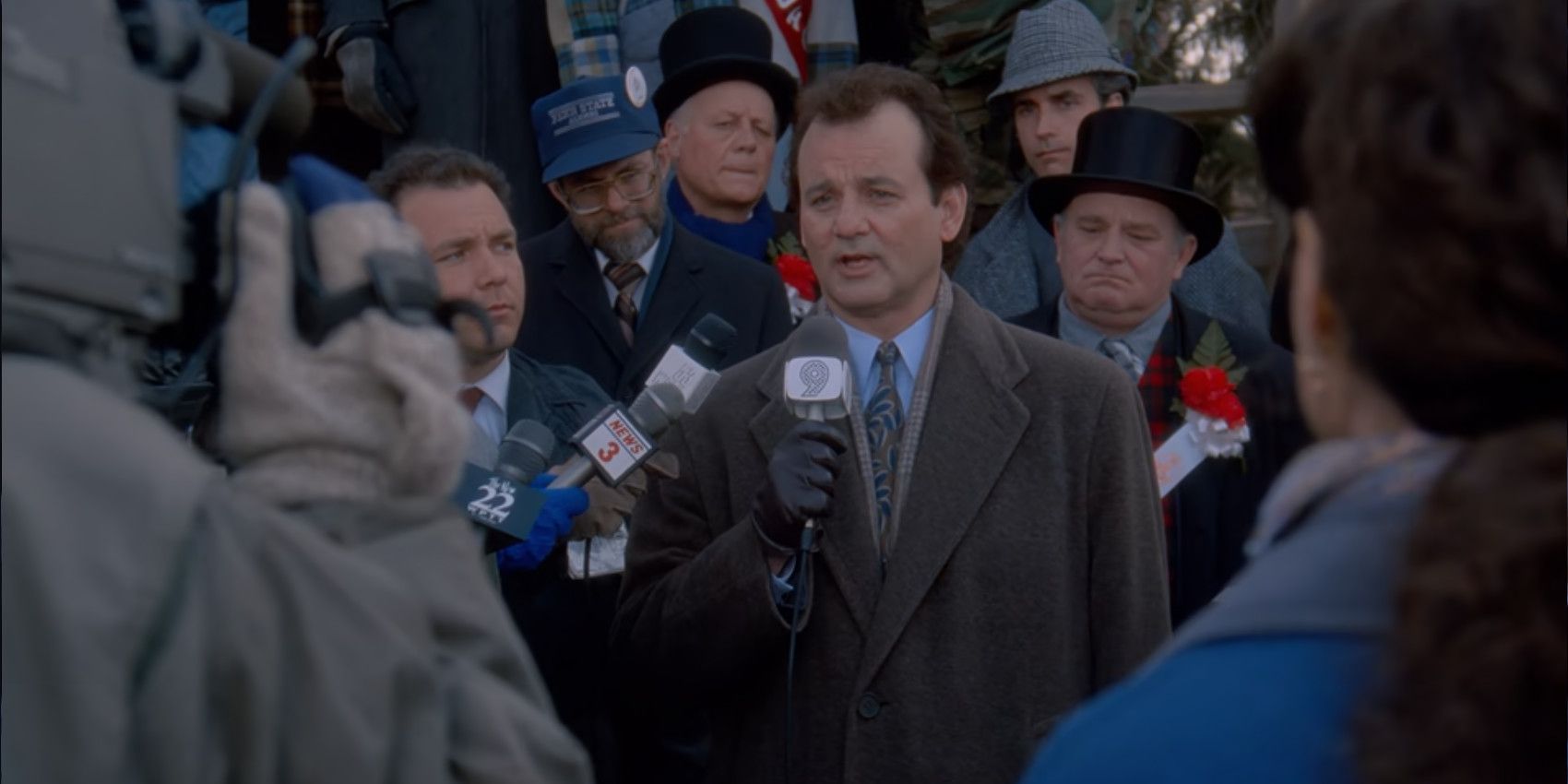Phil (Bill Murray) is surrounded by microphones as he does his morning broadcast in Groundhog Day.