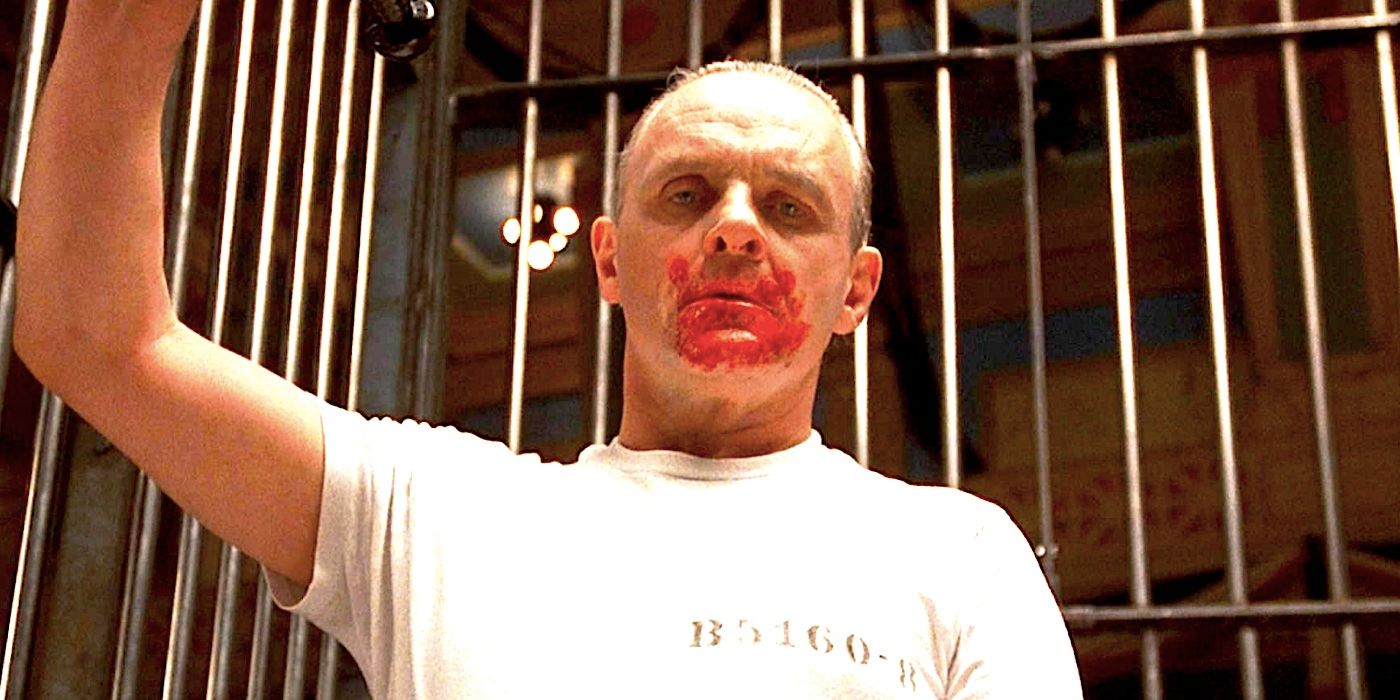Sir Anthony Hopkins as Hannibal Lecter staring down with a bloodstained mouth inside a cage in Silence of the Lambs