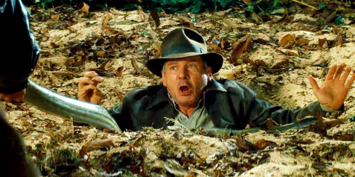 Harrison Ford as Indiana Jones submerged up to his chest in quicksand as a snake is held in front of him in Indiana Jones and the Kingdom of the Crystal Skull.