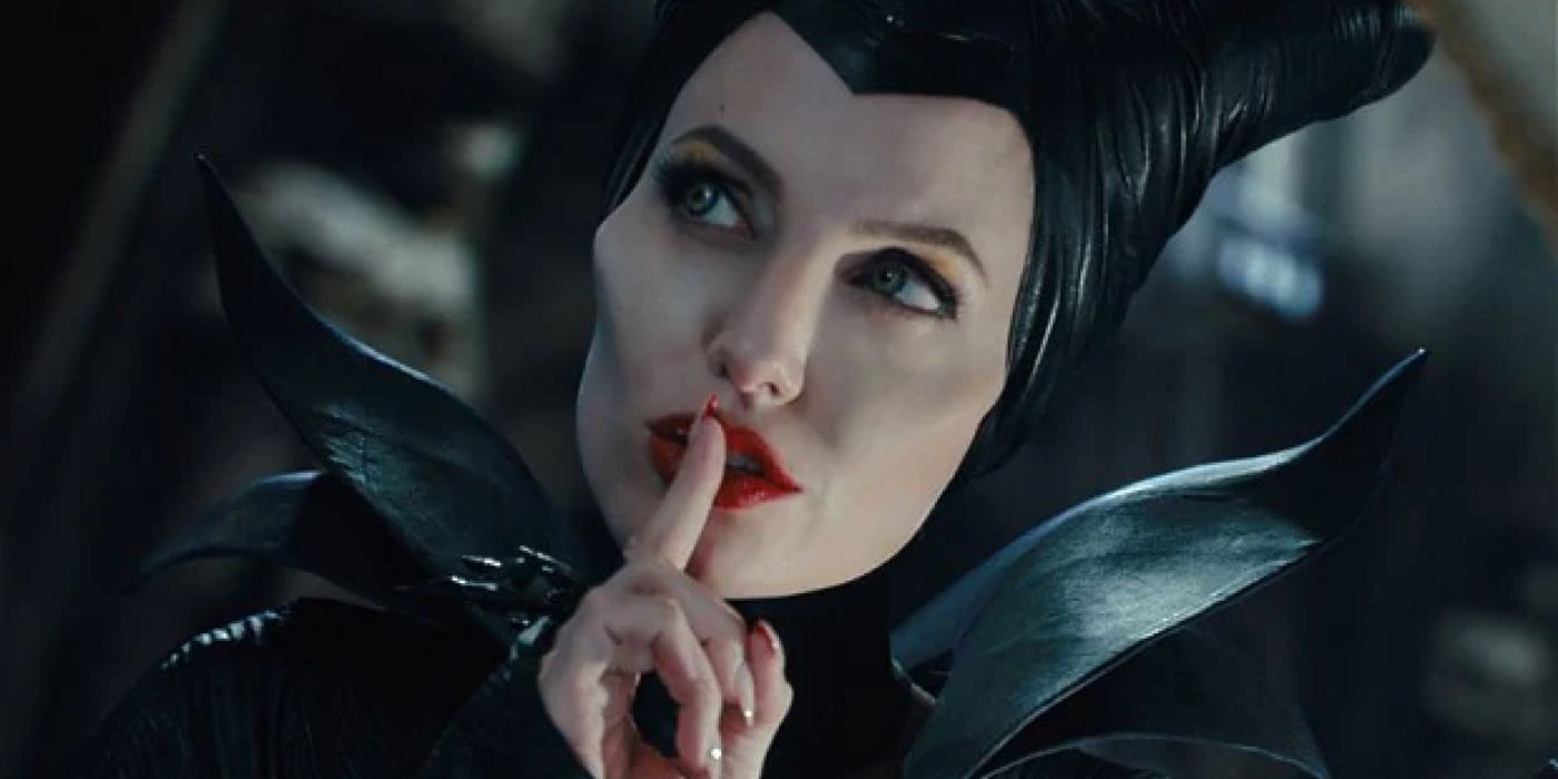 Maleficent holds a finger to her lips. 