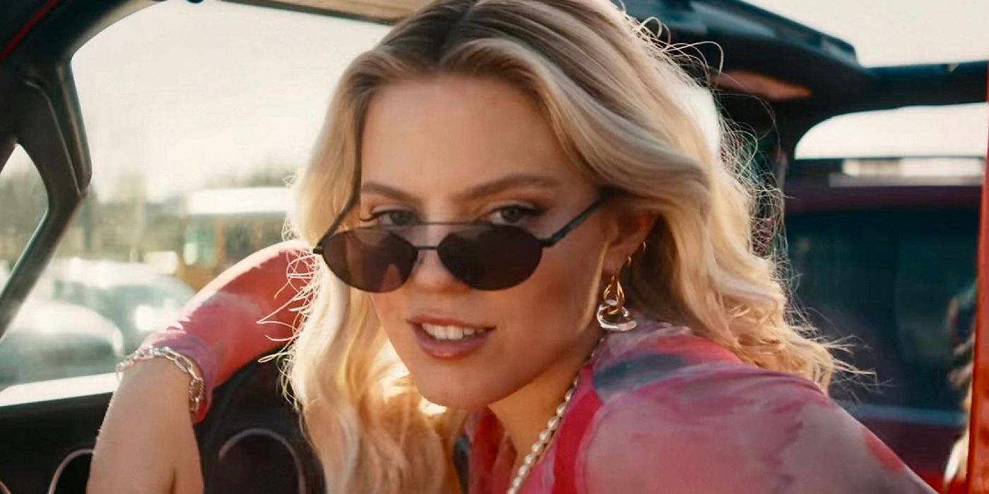 Reneé Rapp as Regina George is in her car with her shades down on her nose, looking into the camera in the Mean Girls 2024 movie musical. 