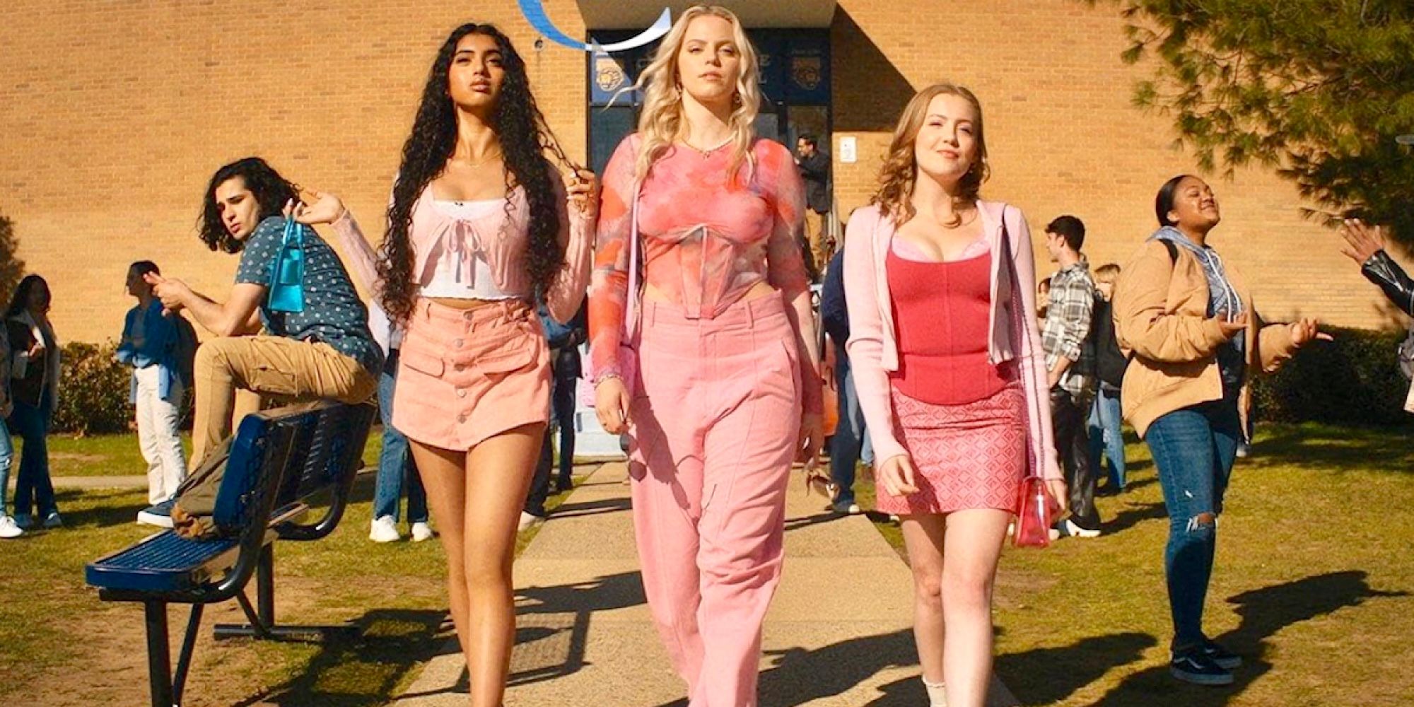 Los Plásticos caminando afuera de la escuela en la película musical Mean Girls 2024. 