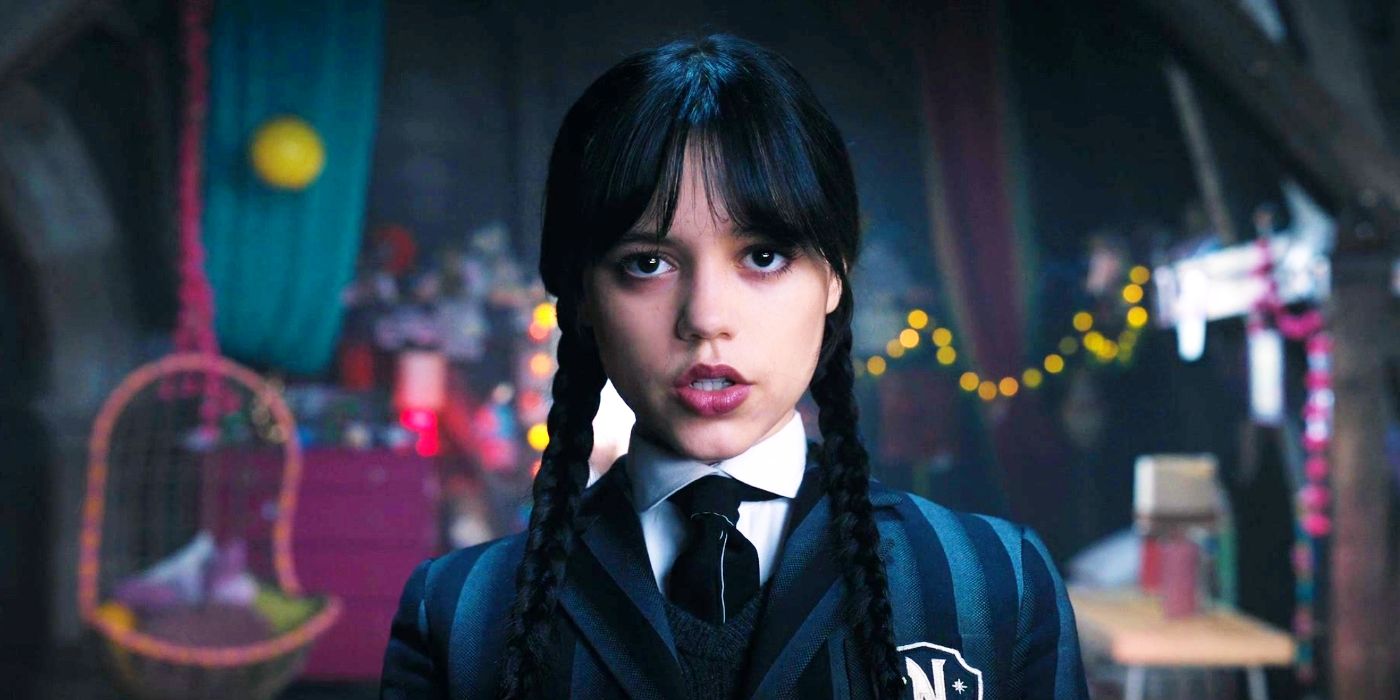 Jenna Ortega staring into the camera and standing in a colorful room in Wednesdsay.