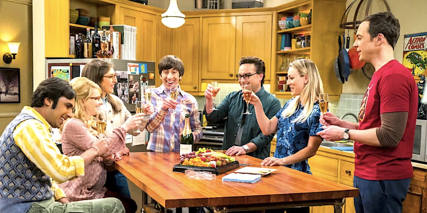 Johnny Galecki as Leonard, Melissa Rauch as Bernadette, Jim Parsons as Sheldon, Kunal Nayyar as Raj, Kaley Cuoco as Penny, Mayim Bialik as Amy, and Simon Helberg as Howard all toast with champagne around a table in The Big Bang Theory