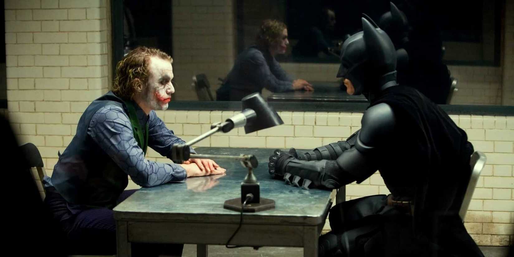 O Coringa de Heath Ledger e o Batman de Christian Bale se encontram cara a cara em uma sala de interrogatório no Cavaleiro das Trevas