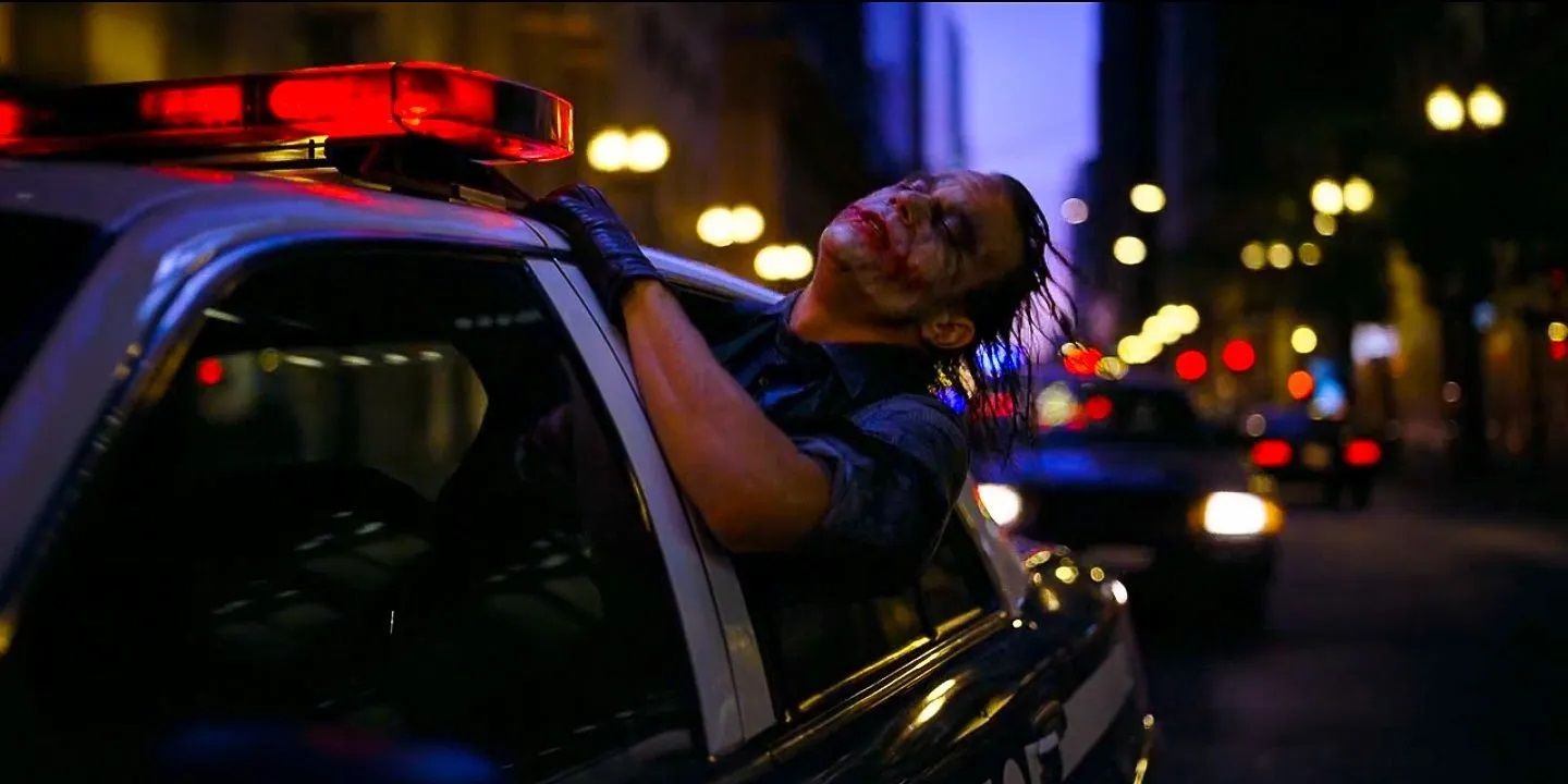 Heath Ledger como el Joker sacando la cabeza por la ventanilla de un coche de policía en El caballero oscuro