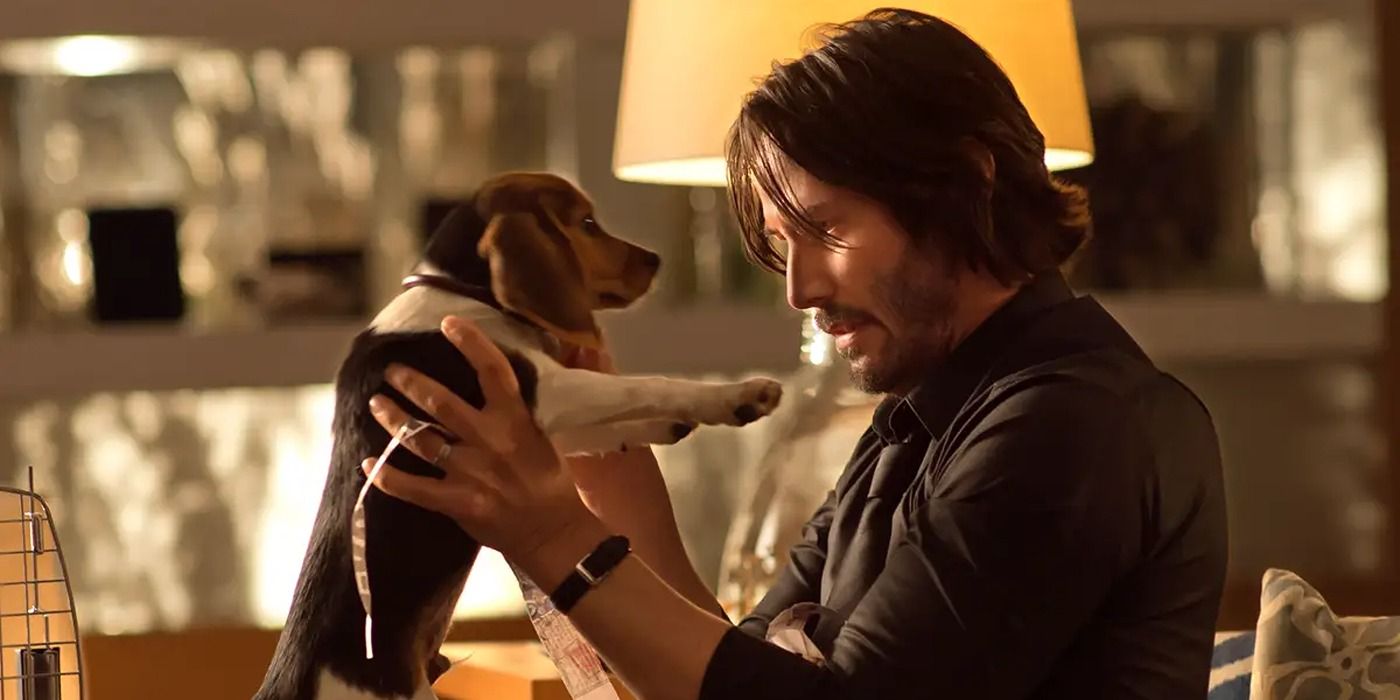 Keanu Reeves como John Wick sosteniendo un cachorro en John Wick