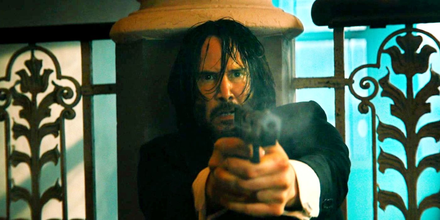 Keanu Reeves leaning against a pillar and pointing a gun in John Wick: Chapter 4.
