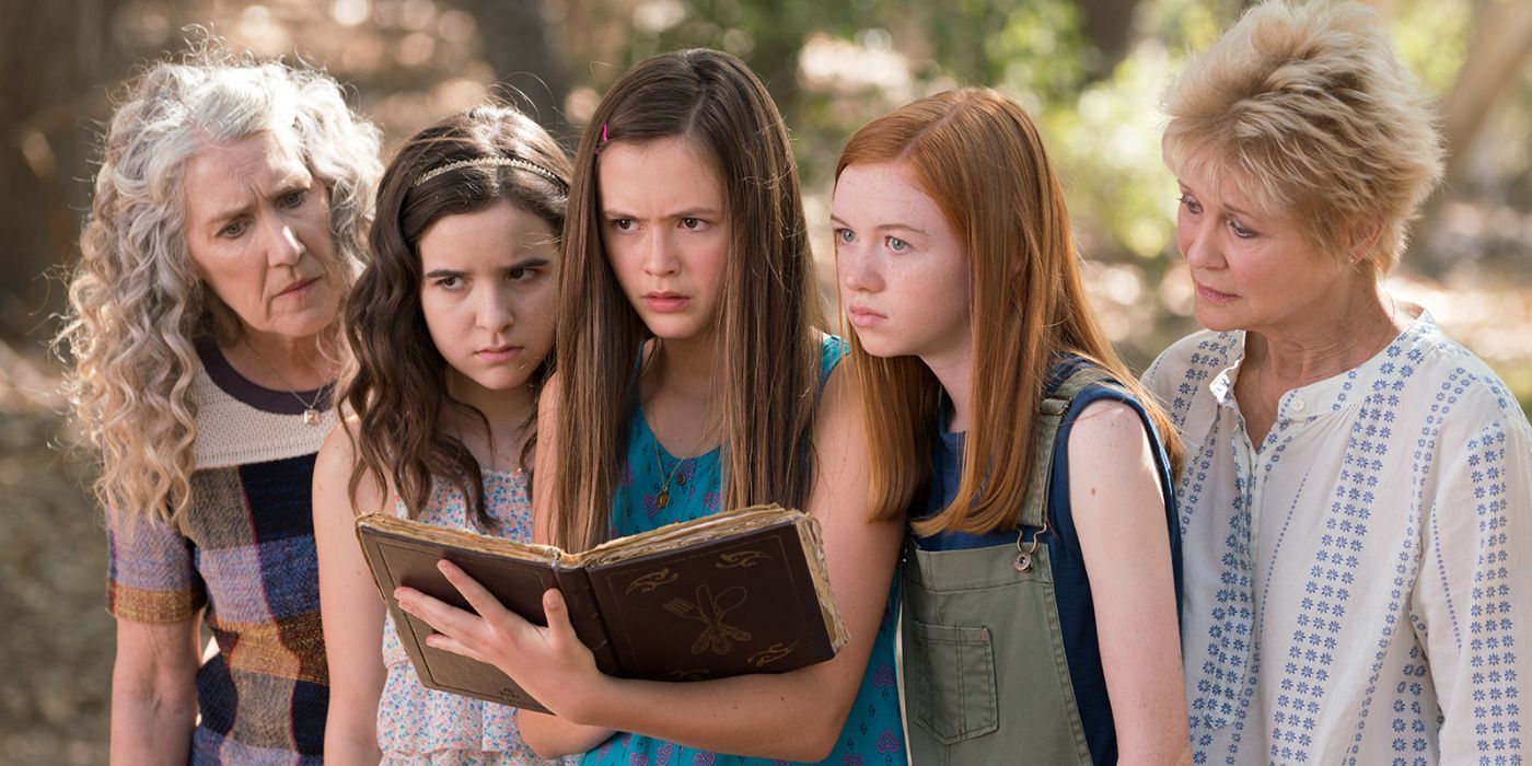 Kelly, Darbie, Hannah, Teri, and Grandma Becky standing together and reading from a magic book in Just Add Magic.