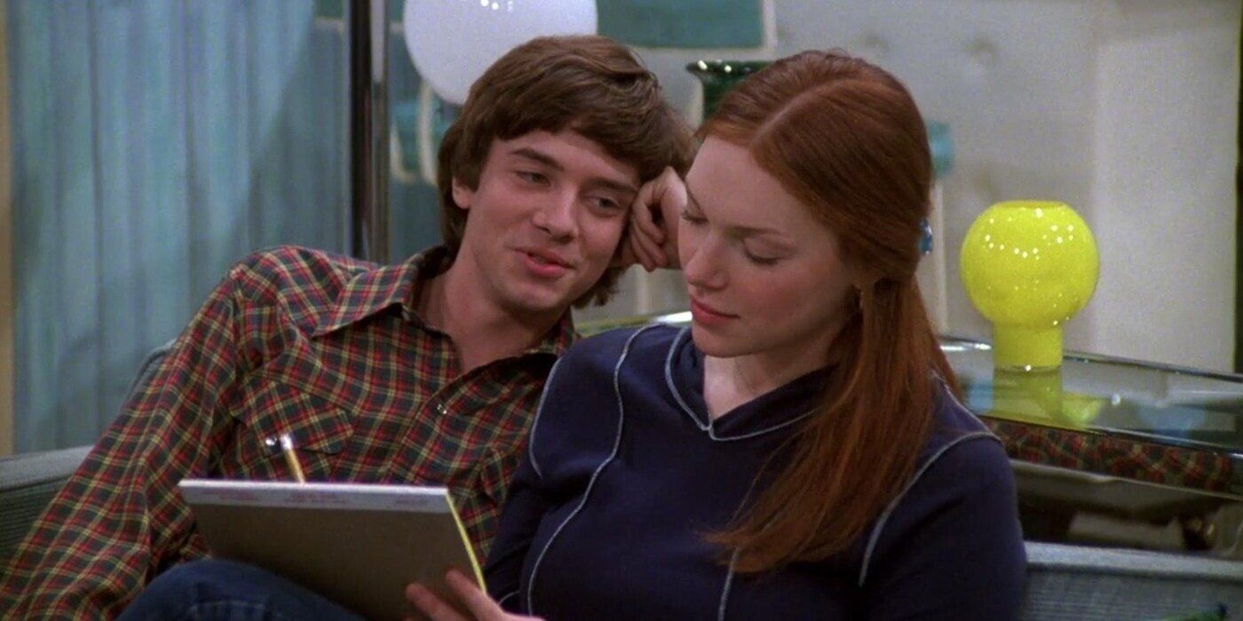 Eric (Topher Grace) gazing at Donna (Laura Prepon) while she writes on a legal pad in That '70s Show.