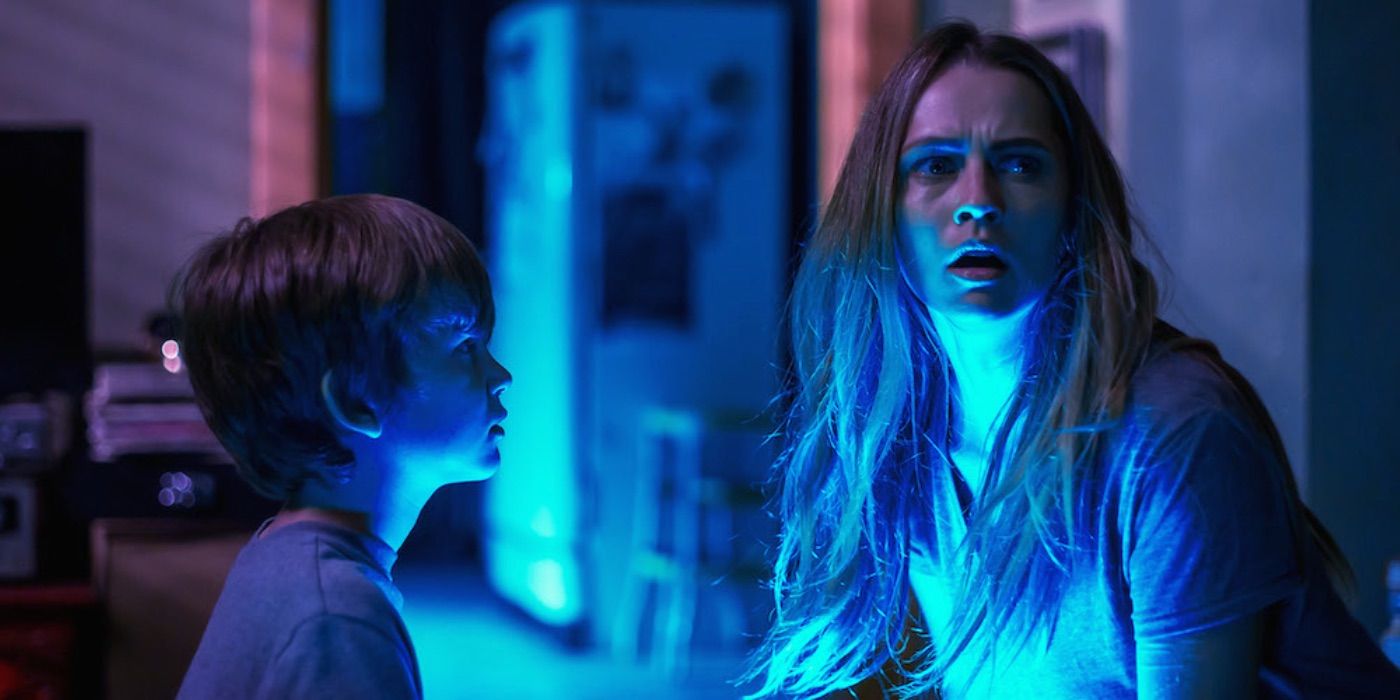 Rachel looking shocked in blue light in Lights Out