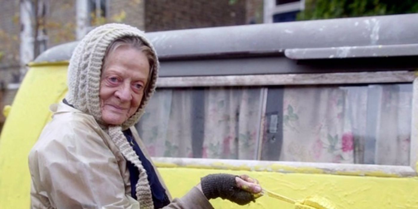 Maggie Smith como Miss Shepherd sorrindo do lado de fora de uma van amarela em The Lady in the Van