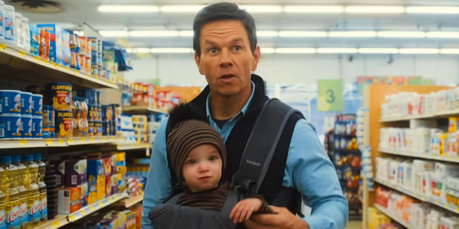 Dan (Mark Wahlberg) carrying a baby in The Family Plan