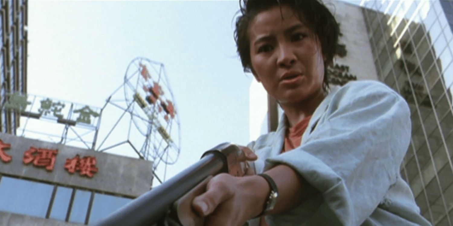 Michelle Yeoh holds a shotgun pointed downward in Yes Madam!