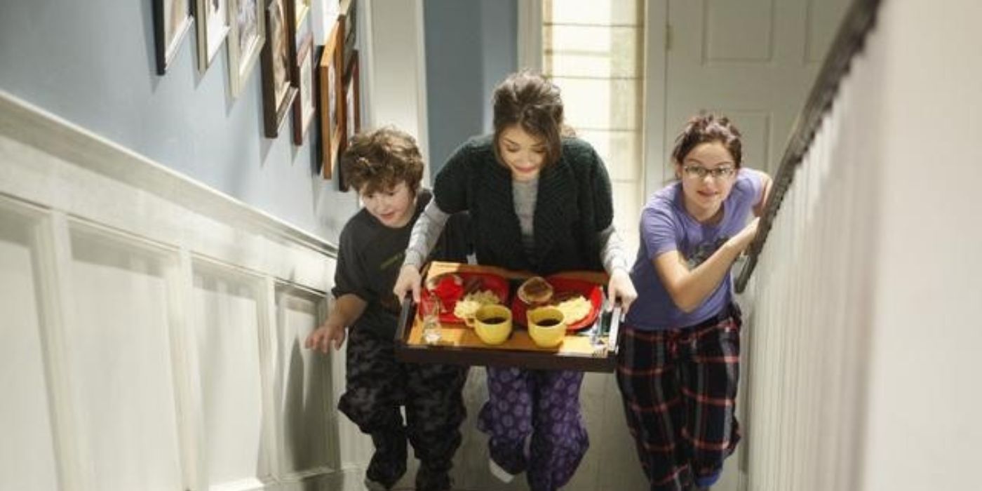 Hayley, Luke, and Alex running up the stairs with breakfast in Modern Family season 2