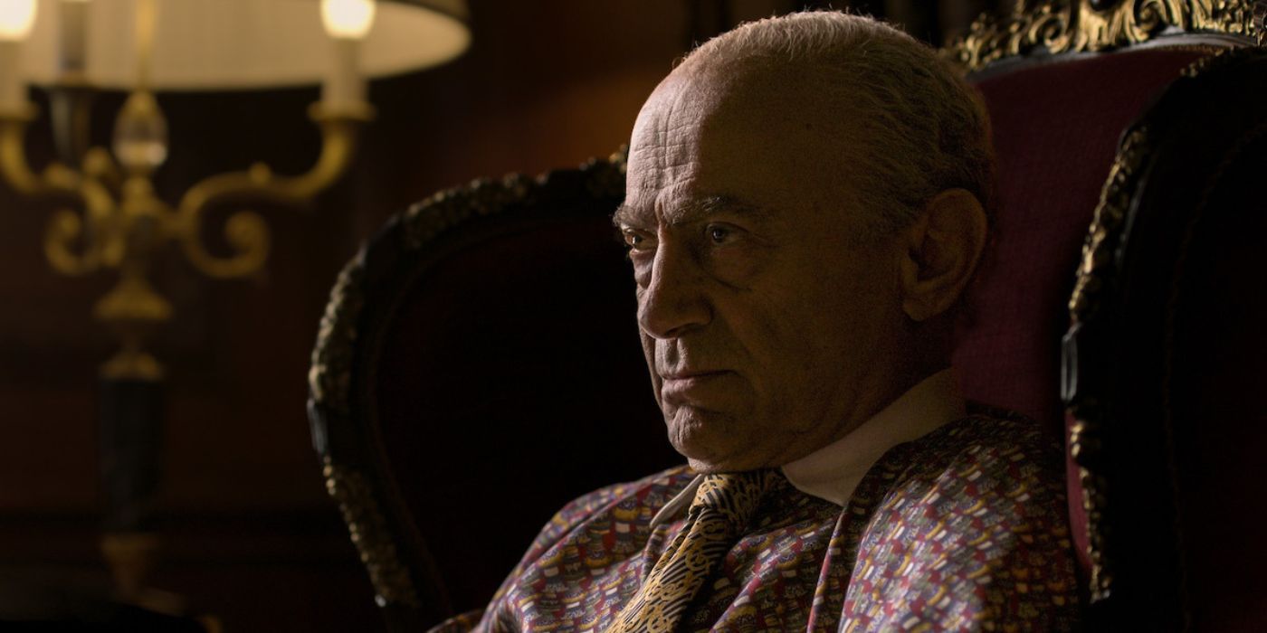 Mohamed Al-Fayed (Salim Daw) sits in a throne chair while staring angrily in The Crown Season 6.