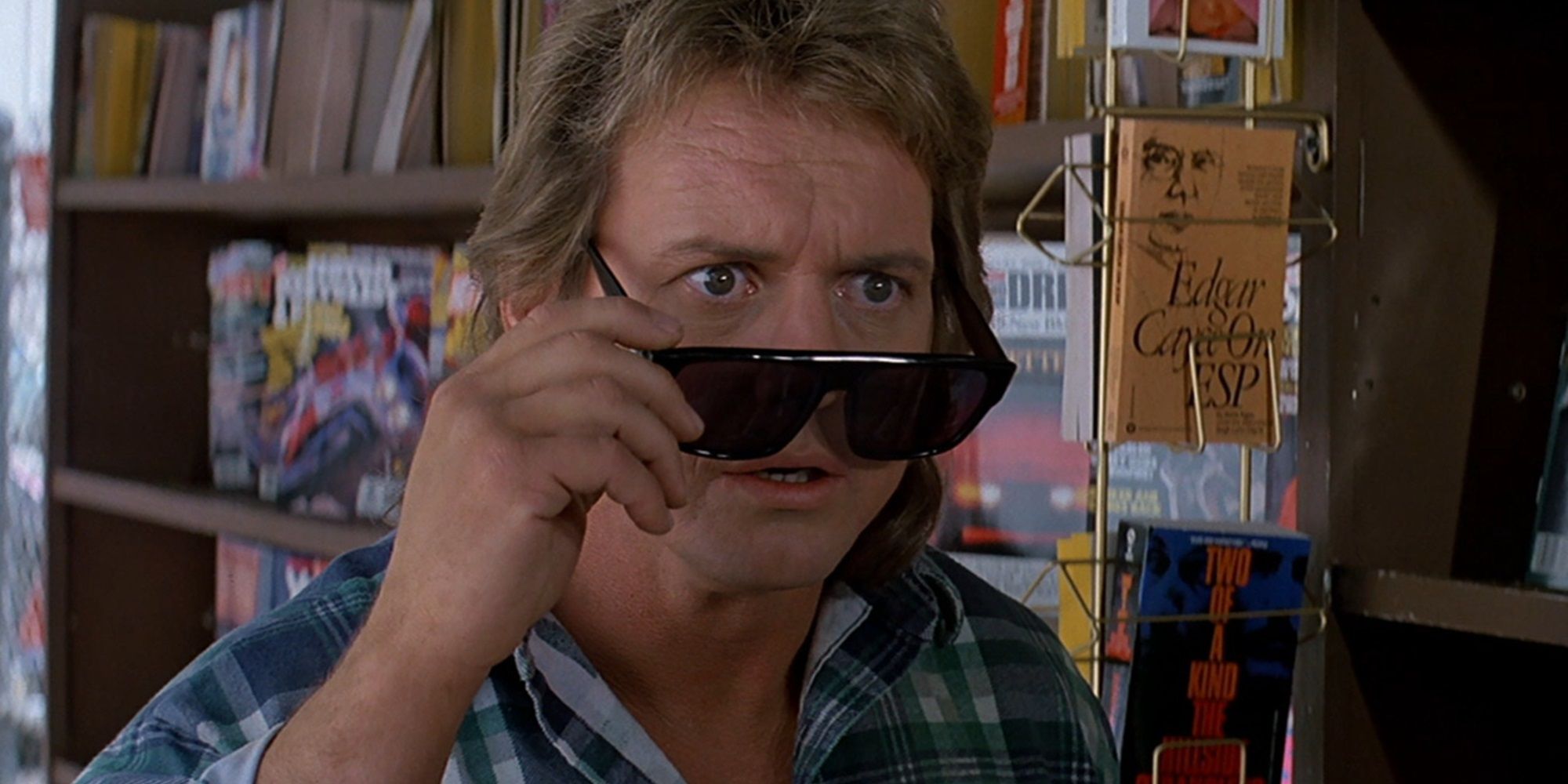Nada peeks past his glasses in They Live