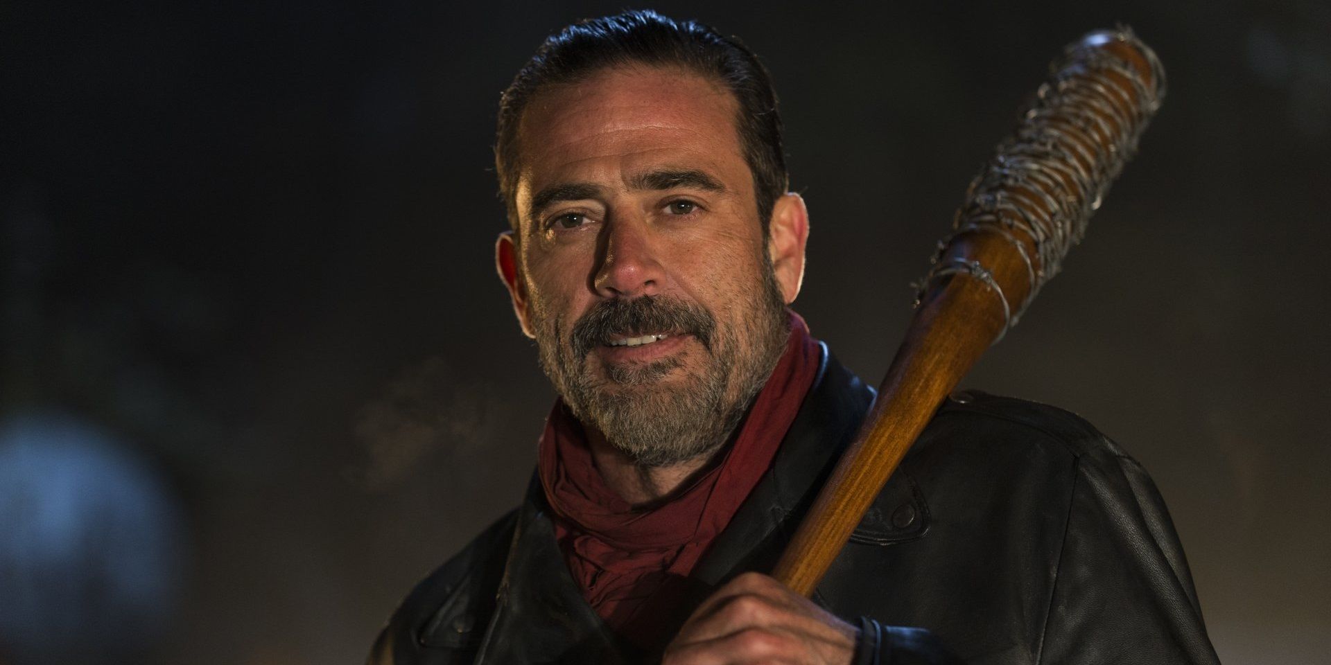 Jeffery Dean Morgan as Negan smiling and holding his bat, Lucille, in The Walking Dead.