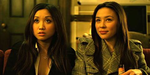 Brenda Song and Malese Jow sitting next to each other, looking at someone offscreen in The Social Network