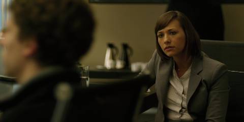 Rashida Jones as Marylin Delpy looking over at Jesse Eisenberg as Mark Zuckerberg inin The Social Network.