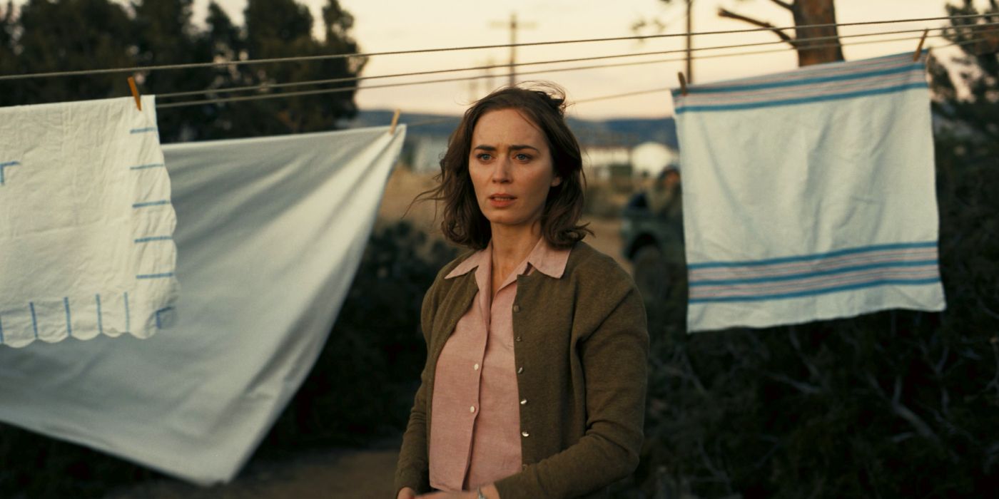 Emily Blunt as Kitty in front of a laundry line in Oppenheimer.
